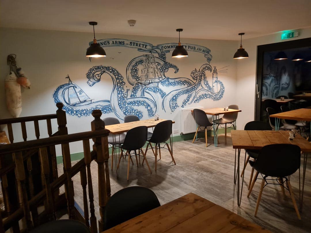 Inside The Kings Arms, a view of the seating area, with a huge octopus illustration on the wall.